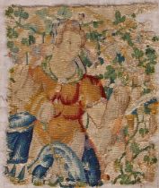 A 17th Century tapestry fragment, depicting a woman among a leafy tree, mounted on a backing