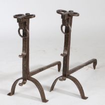 A pair of 17th Century iron firedogs, with loops to the top above two hooks and arched supports,