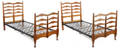 A pair of Heals & Son oak single beds, with arched ladder backs and turned uprights on block and