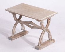 A limed oak low stool, the rectangular seat raised on pierced gothic style X-form legs, pierced