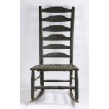 An early 20th Century blue painted ladderback rocking chair, the cane seat on turned legs and