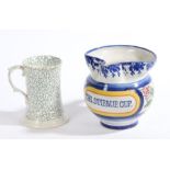 A pottery jug inscribed "THE STIRRUP CUP", 15cm high, together with a porcelain mug with seaweed