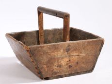 A wooden trug with turned handle and tapering ends, 32cm wide, 26cm deep, 23.5cm high