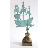 A weathervane modelled as a three masted ship, presented on a gadrooned reconstituted plinth base,