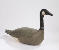 An early 20th Century decoy goose, the canvas body painted white, black and grey and a hook to the