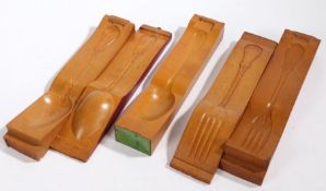 Five cutlery moulds to include three spoons and two forks, 36cm long (5)