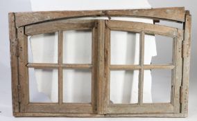 A 19th Century pine window frame, the arched frame with two windows, 141cm wide, 85cm high