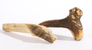 Two carved antler walking stick handles, one carved as a bulldog with bead eyes, 13cm wide, the