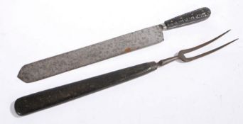 An early 19th Century oversized carving knife and fork, the knife with carved scroll decoration, the