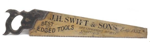 A large painted wooden advertising sign in the form of a saw, inscribed, J H Swift & Sons,