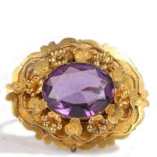 A Victorian amethyst and yellow metal brooch, the oval facetted amethyst set to a flower and petal