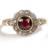 An 18 carat gold ruby and diamond set ring, with a central ruby and diamond surround, 4.2 grams,
