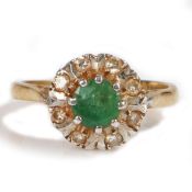 An 18 carat gold emerald and diamond set ring, with a central emerald and diamond surround, 3.6