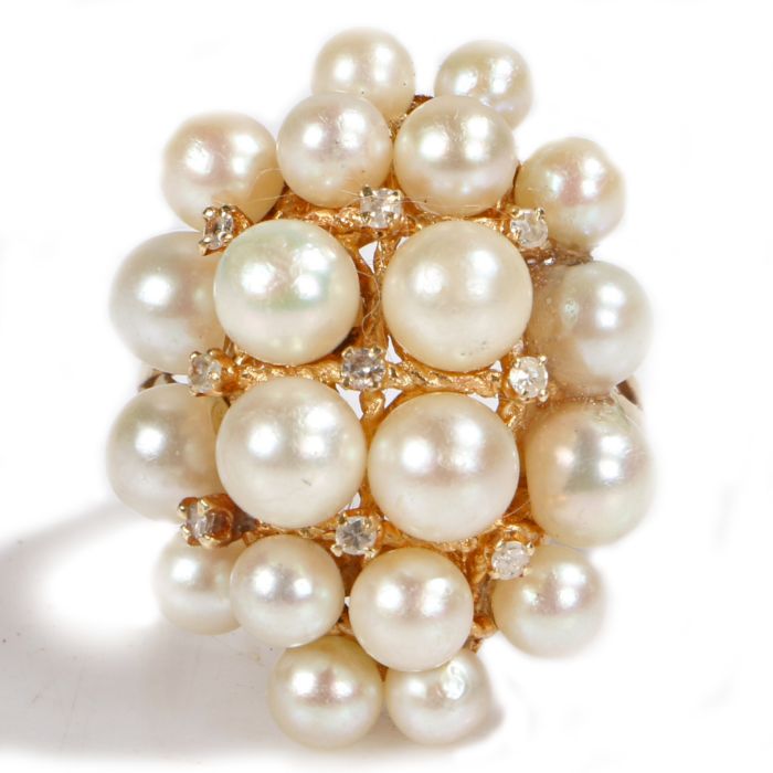 A pearl encrusted cocktail ring, with nine round cut diamonds interspersed between the pearls, 11