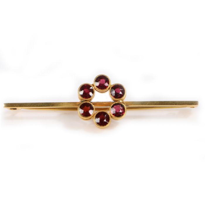 A 9 carat gold and garnet set brooch, with six garnets in a circle to the bar, 3.5 grams, 58mm