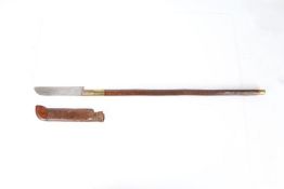 A Cowen`s Patent machete stick, maker marked blade (20 cm) with leather and wood scabbard, wooden