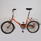 Vintage 'Super de Luxe' fixed gear folding bicycle in orange.