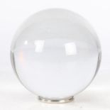 Crystal ball marked with the Baccarat logo (14cm diameter), raised on a small metal stand.