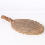 A Robert "Mouseman" Thompson chopping board, the oval board with a handle set with a mouse, 38cm