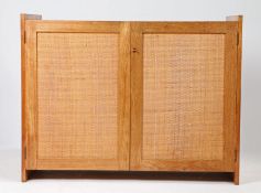 A mid Century teak side cabinet with woven cane work doors. 98cm wide x 75cm high x 51cm deep.