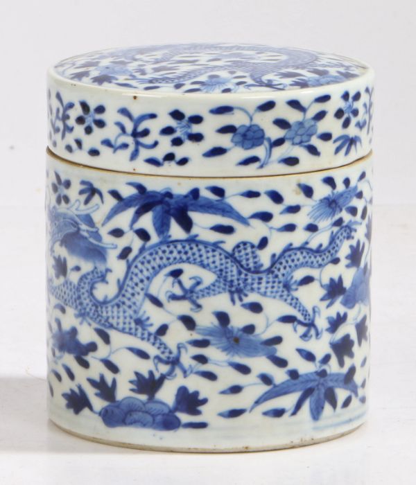 A Chinese porcelain cylindrical box and cover, in blue and white with a dragon among flowers, chip