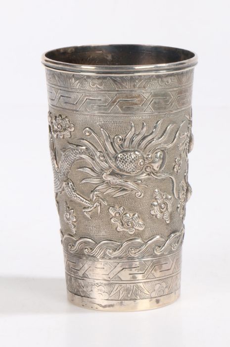 A 19th Century Chinese export silver beaker, the tapering body decorated in relief with a dragon