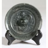 A Chinese bronze mirror, Six Dynasties Period (220-589) cast around the central pierced knob with