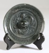 A Chinese bronze mirror, Six Dynasties Period (220-589) cast around the central pierced knob with