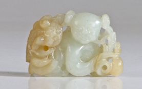 A Chinese white jade group, carved as a boy and Buddhist lion, the jovial figure crouching and