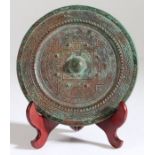 A Chinese bronze mirror, Han Dynasty, 206 BC -220 AD, the raised central knob with eight bosses