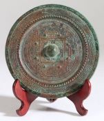 A Chinese bronze mirror, Han Dynasty, 206 BC -220 AD, the raised central knob with eight bosses