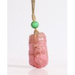 A Chinese tourmaline pendant, carved as section of bamboo with two dogs of foo, the reverse with a