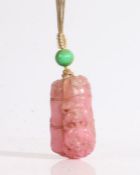 A Chinese tourmaline pendant, carved as section of bamboo with two dogs of foo, the reverse with a