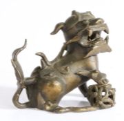 Chinese bronze temple lion, with one paw raised and jaw open, 12.5cm long 10.5cm high