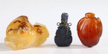 A Chinese carnelian carved peach pendant, a lapiz lazuli snuff bottle and an agate ornament in the