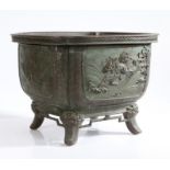 A Japanese Meiji period bronze jardinière, the square body with rounded corners having four panels