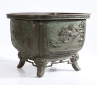 A Japanese Meiji period bronze jardinière, the square body with rounded corners having four panels