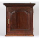 A mid-18th century oak mural spice cabinet The stepped pediment above a fielded panelled door,