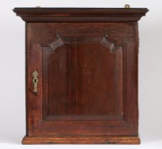 A mid-18th century oak mural spice cabinet The stepped pediment above a fielded panelled door,