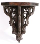 A 19th century carved oak Gothic-Revival bracket, English The rectangular top with canted front