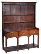 A George III oak high dresser, South Wales, circa 1760 The boarded rack with two shelves, the open