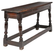A James I oak bench or form, circa 1620 The one-piece top with ovolo-moulded edge, the rails with