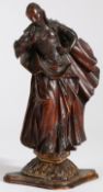 An 18th century limewood figural carving   Female, designed standing, one hand on hip, wearing a