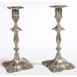 A pair of George II paktong candlesticks, one with maker’s mark, circa 1750 In the Rococo manner,