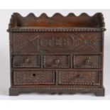 An early 18th century oak spice cabinet, dated 1714 Having a hinged top and carved frieze initialled