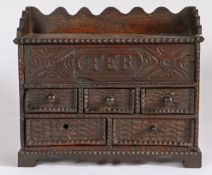 An early 18th century oak spice cabinet, dated 1714 Having a hinged top and carved frieze initialled