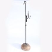 A 19th century wrought iron adjustable standing rushnip holder, on a wooden base The upper round-