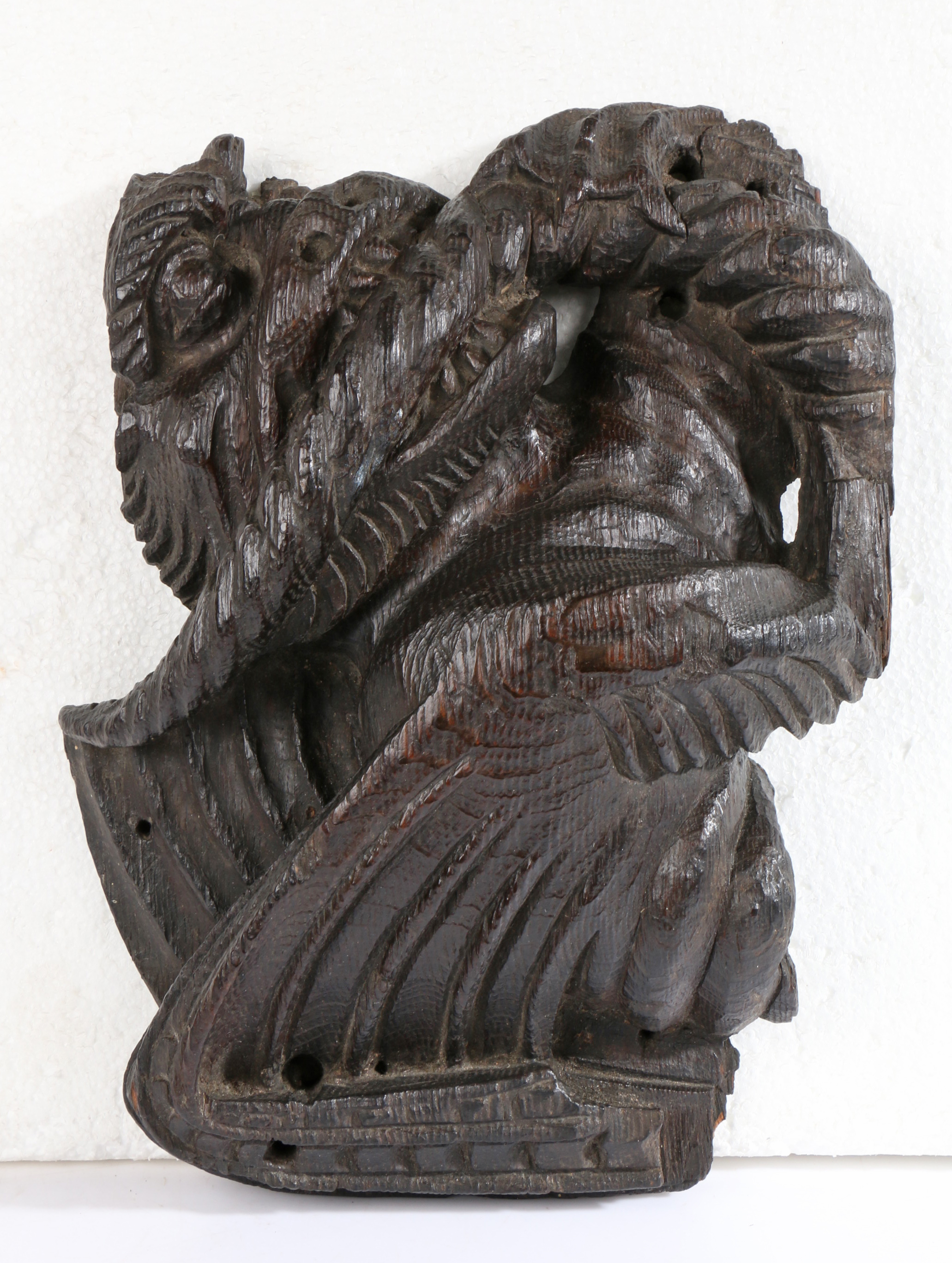 A rare 15th century oak dragon-carved boss, English, circa 1400 The snarling, winged beast clenching