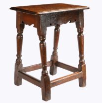 A Charles I oak joint stool, circa 1640 Having an ovolo-moulded top, bicuspid-shaped rails, on