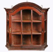 An oak astragal-glazed mural cupboard, Dutch, circa 1800 Of canted form, with arched cornice, atop a
